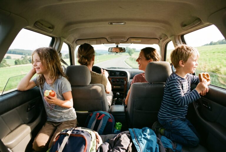Kinder schauen auf der Autofahrt zum Ausflug aus dem Fenster